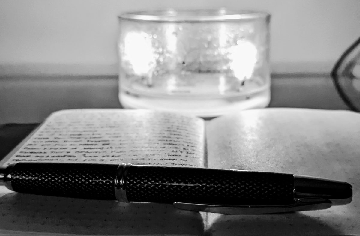 notebook with pen and candle